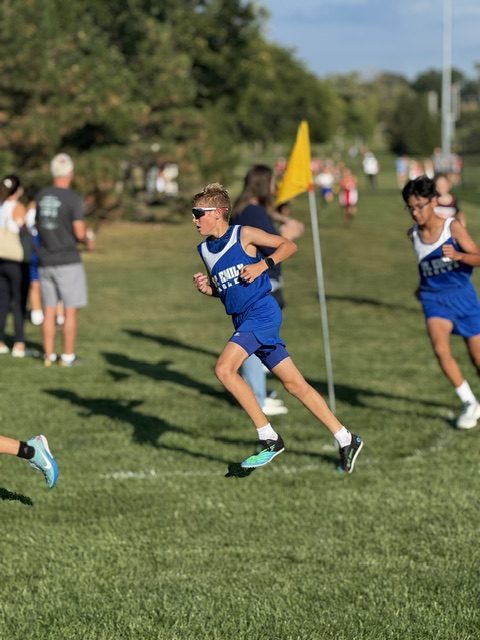 St. Emily Eagles cross country runner with the team flag